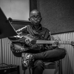 un joven toca la guitarra
